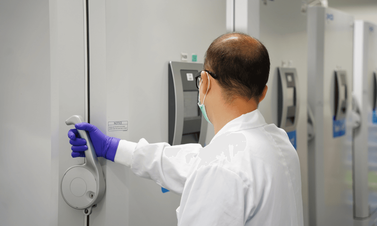 A scientist opening a freezer in a lab.
