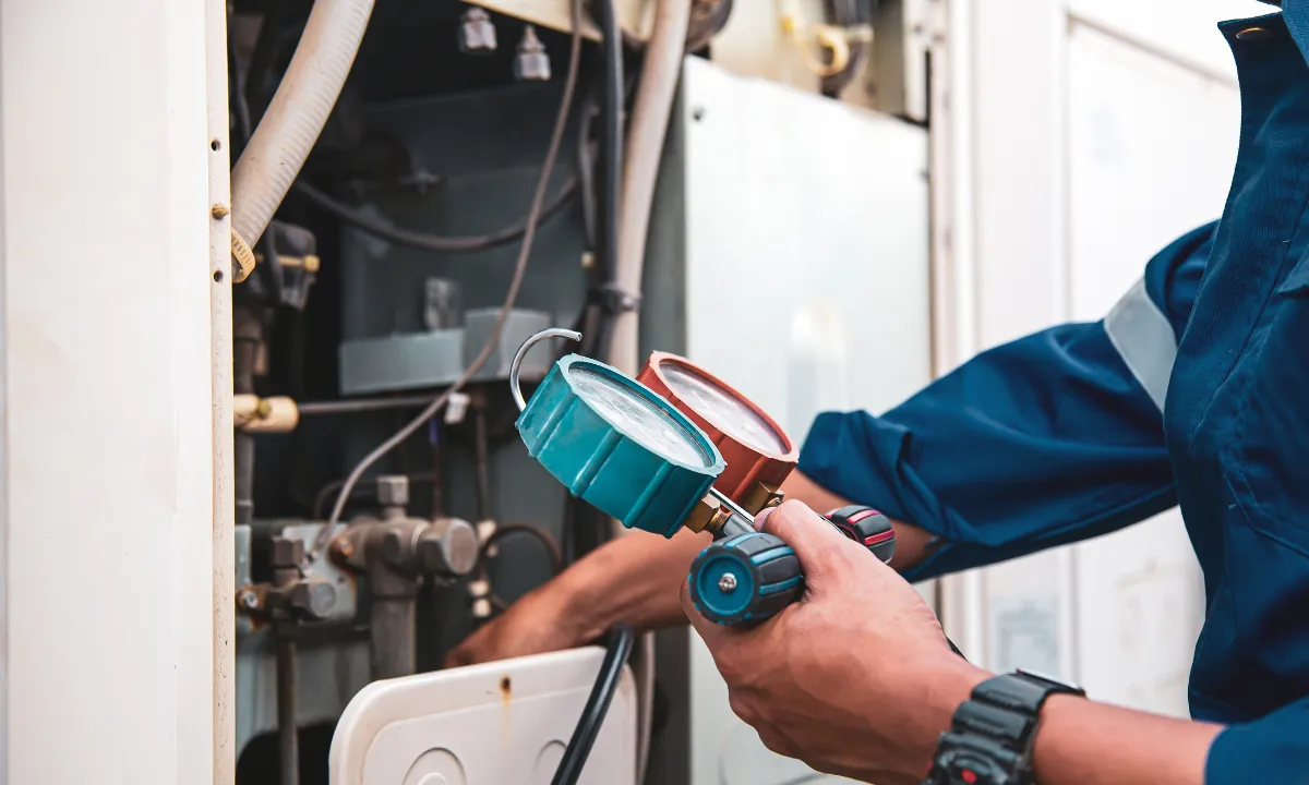 An HVAC technician checking an air-conditioner